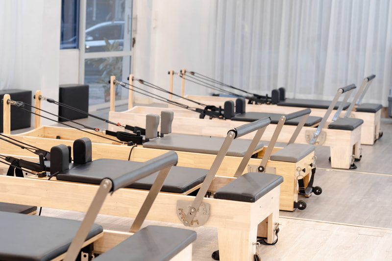 Row of unoccupied Pilates Reformers